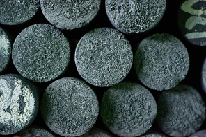 Directly above view of graphite manufactured articles of unequal height standing at production department of modern plant, close-up shot