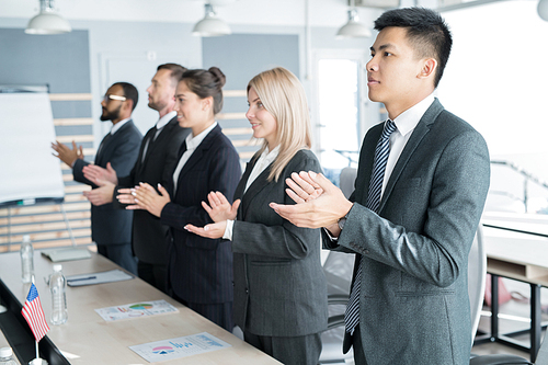 Multiethnic business people standing and applauding after business conference