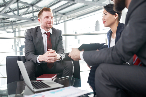 Young businessman sitting at a meeting together with his partners