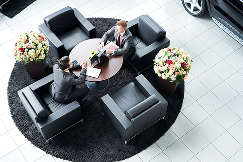 Two partners sitting at the comfort chairs and planning business together