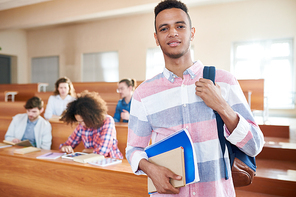 Portrait of Afroamerican student standing at school with books