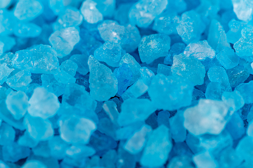 Background macro shot of blue crystals of salt, mineral or chemical reagent, copy space
