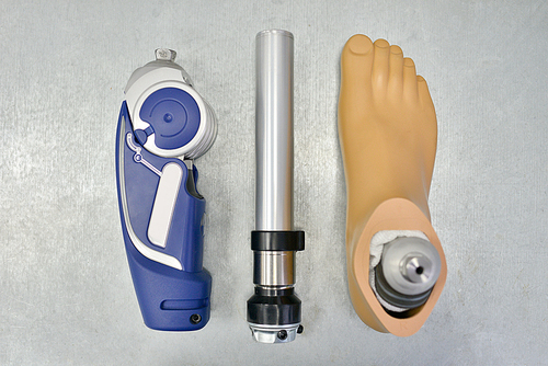 Above view background of disassembled prosthetic leg and foot on table in orthopedic equipment shop, disability concept