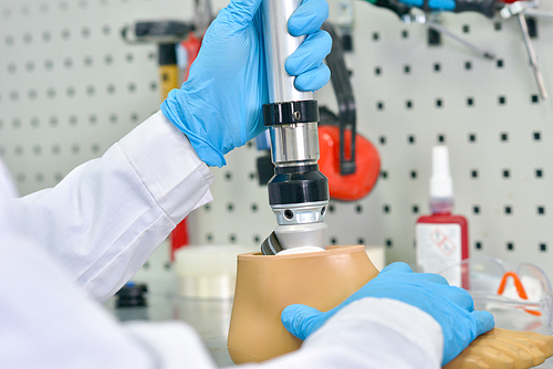 Close up shot of unrecognizable prosthetics technician  assembling prosthetic leg in modern  laboratory