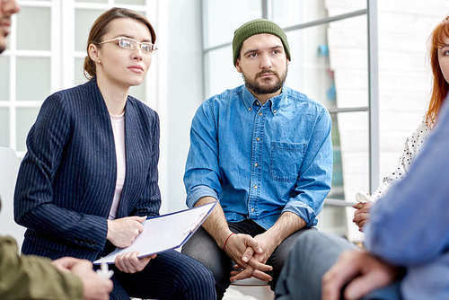 Unrecognizable patient opening up to highly professional psychiatrist during group therapy session at cozy office
