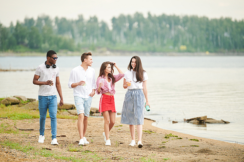 Multiethnic young people having their leisure time on the nature. They walking on the beach