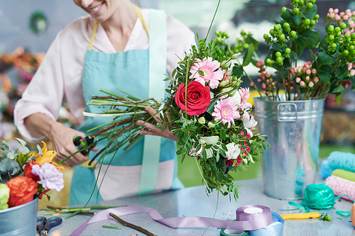 Crop view of smiling florist snipping flower stems