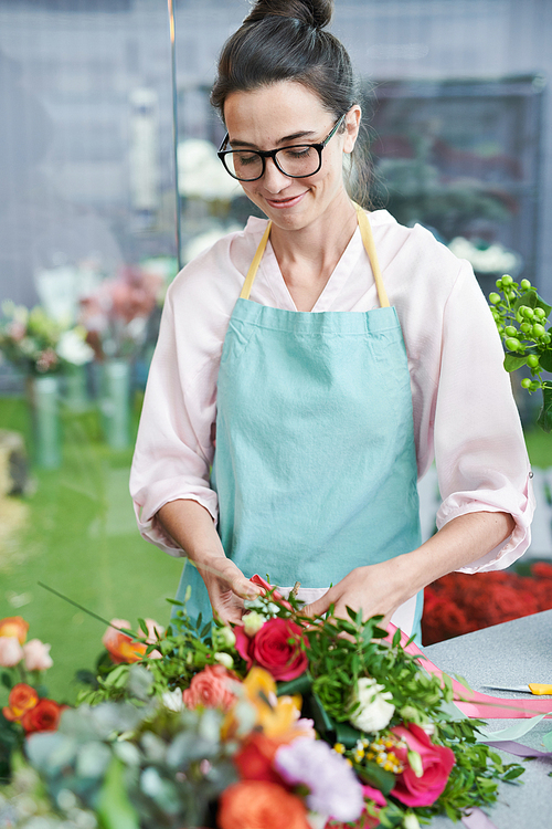 Waist up portrait of modern young woman arranging beautiful bouquets while working in flower shop