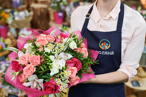 Mid section portrait of unrecognizable female florist holding beautiful rose bouquet while working in flowers shop, copy space