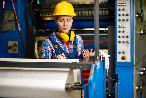 Portrait of beautiful woman checking machines  in modern factory working in quality control