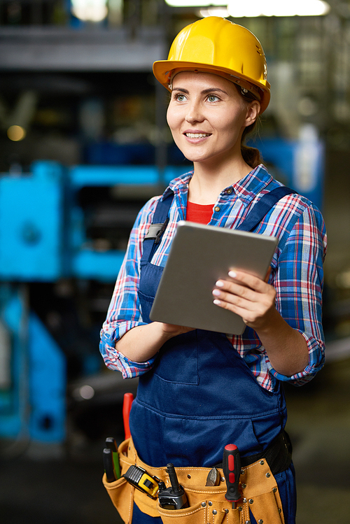 Portrait of female factory worker using digital tablet and smiling