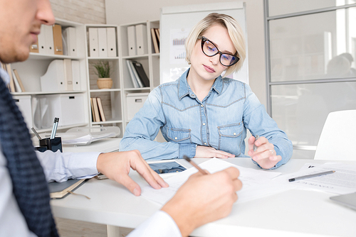 Portrait of two modern business people man and woman planning project sitting at table during meeting in office