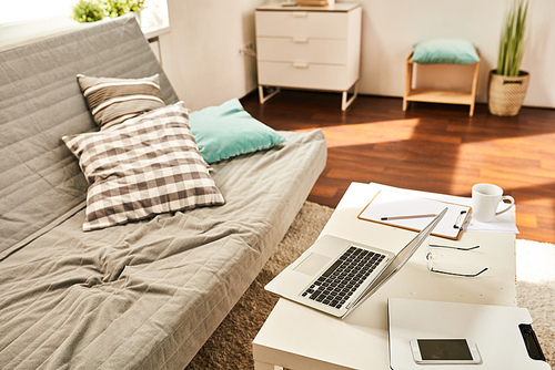 Background image of laptop on table in living room with no people, home office concept