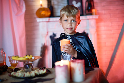 Portrait of little boy wearing Halloween costume posing  in decorated studio