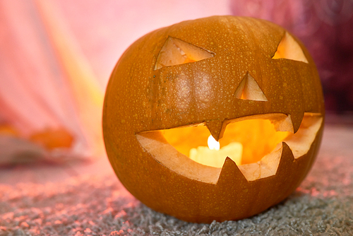 Halloween background image of lit pumpkin lantern in spooky light, copy space