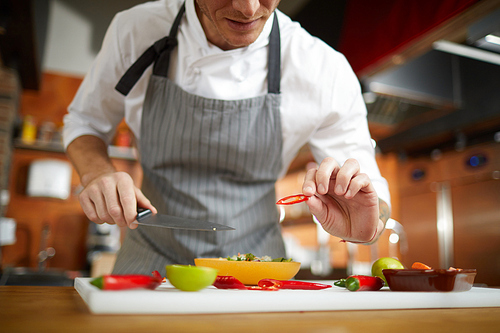 Mid section portrait of unrecognizable chef cutting vegetables in restaurant, copy space