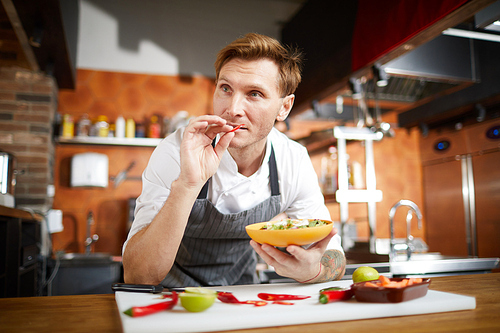 Portrait of professional chef cooking vegetables in restaurant kitchen, copy space