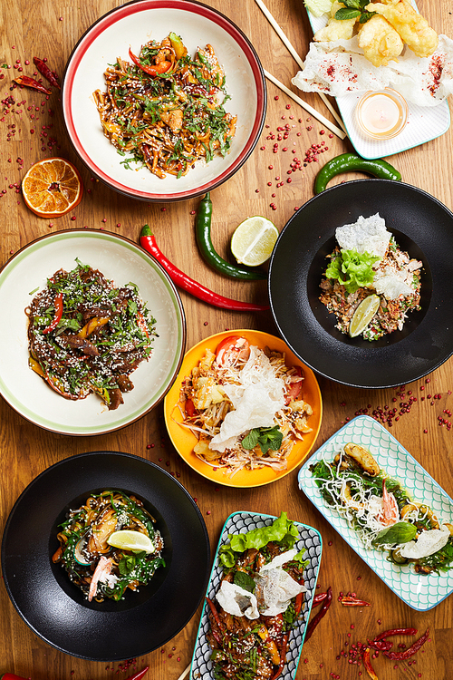 Top view background composition of several Asian food dishes on wooden table, copy space