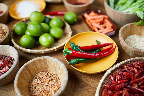 Close up background of various spices and ingredients in wooden bowls on table, copy space