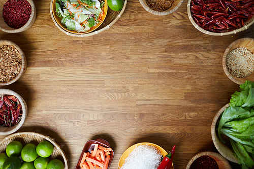 Food background of various spices standing on wooden table with empty space