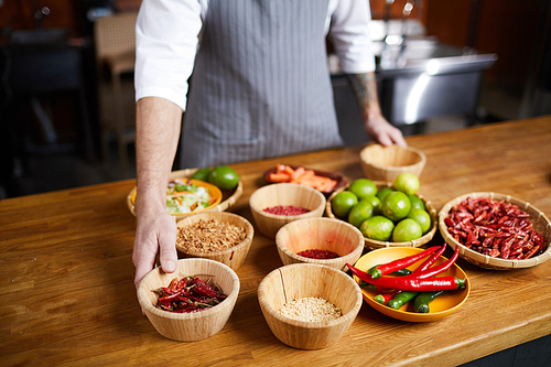 Mid section portrait of professional chef choosing aromatic spices while cooking in restaurant kitchen, copy space
