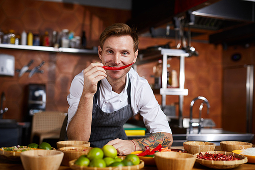 Portrait of professional chef holding red chili pepper and , copy space