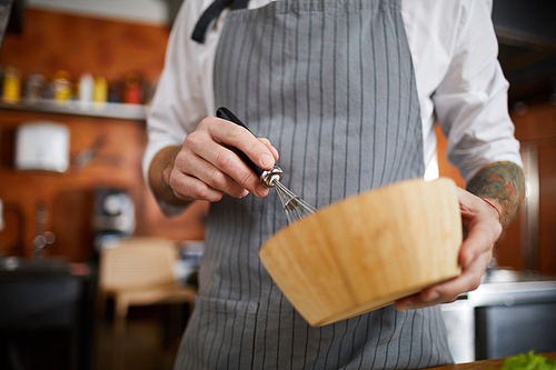Mid section portrait of unrecognizable chef mixing something in wooden bowl with whisk