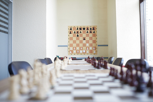 Chess classroom at school with chess poster on wall and long table with  various chess boards