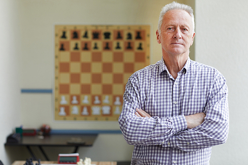 Famous aged male experienced grandmaster posing for pictures after winning chess tournament