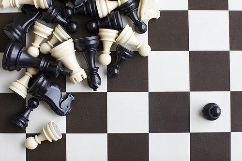 Mix of black and white Randomly scattered lying wooden chess pieces on black and white chess board