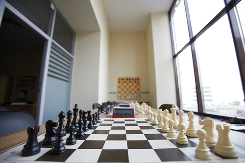 Chess club classroom well prepared for classes with long table, several chess boards and big window