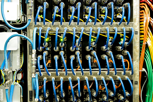 Background image of modern server rack cabinet full of blue cables and wires providing internet in company
