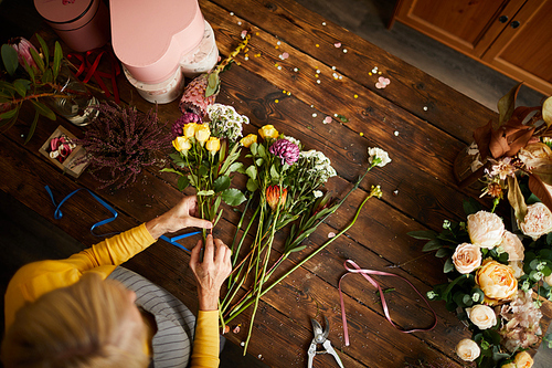 High angle portrait of female florist arranging bouquet while working in flower shop, copy space