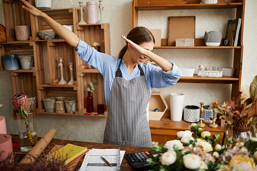 Waist up portrait of female small business owner dabbing celebrating success