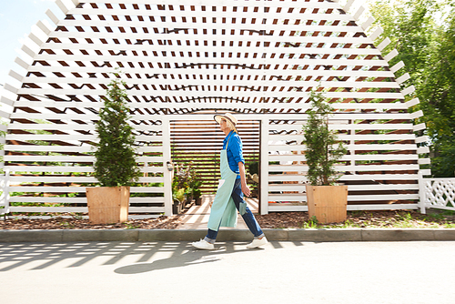 Background image of senior worker walking past greenhouse in planttion, copy space