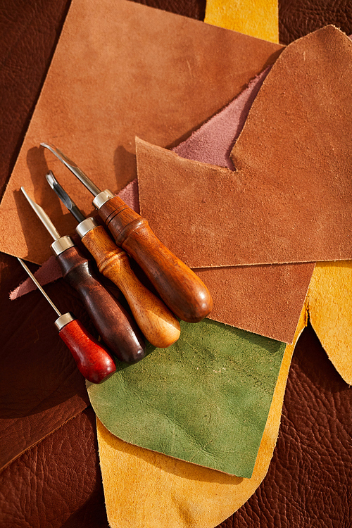 Top view background of real leather and tools lying on table in leatherworking shop, copy space