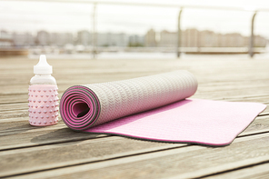 Background image of pink yoga mat set for workout on wooden pier outdoors, copy space
