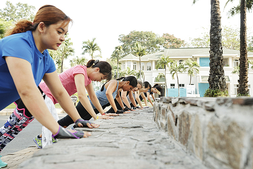 Young women doing press-up exercise after jogging in the morning