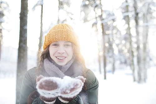 Portrait of happy young woman playing with snow in winter, and , copy space