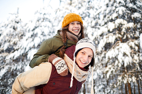 Portrait of active young couple having fun outdoors in winter and , copy space
