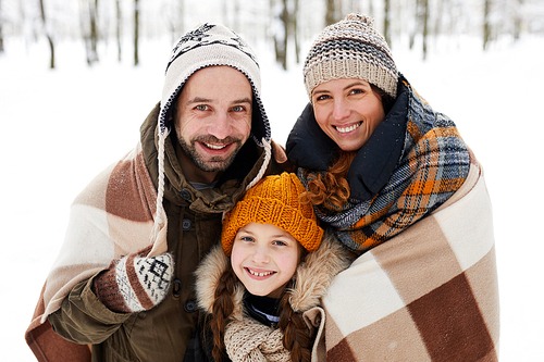 Portrait of happy family in winter forest  and smiling, copy space