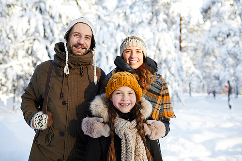 Portrait of happy family posing  in beautiful winter forest, copy space