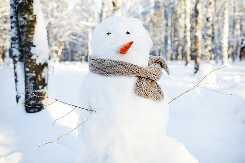 Background image of snowman wearing scarf in beautiful winter forest, copy space