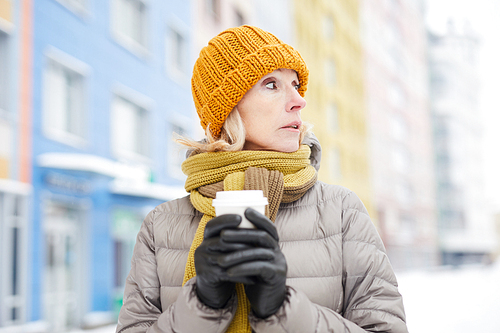 Waist up portrait of modern adult woman drinking hot coffee outdoors in winter, copy space