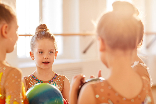 Group of little girls chatting during break in gymnastics class