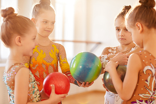 Group of little girls chatting during break in gymnastics school