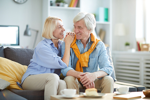 Portrait of loving senior couple looking t each other while enjoying tea at home, copy space