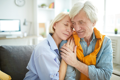 Portrait of mature couple in love embracing tenderly at home , copy space