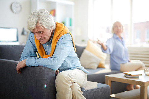 Portrait of modern senior couple fighting focus on frustrated senior man in foreground, copy space