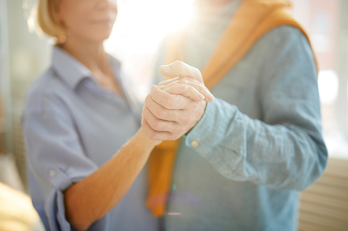 Close up portrait of happy senior couple dancing at home in sunlight, copy space
